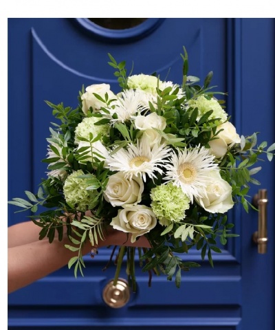 Bouquet de flores brancas e verdes com folhagem junto a uma porta azul
