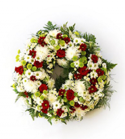 Coroa floral colorida de flores brancas, vermelhas e verdes com folhagem