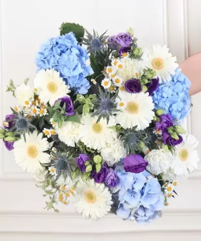 Buquê de flores com hortênsias azuis, margaridas brancas e flores roxas