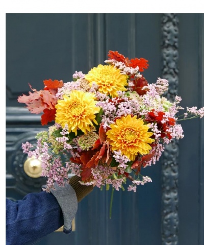 Ramo de flores coloridas com crisântemos amarelos e folhas vermelhas sobre fundo de porta azul