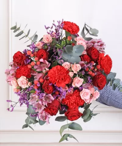 Bouquet colorido de flores variadas com cravos, rosas e folhagem verde