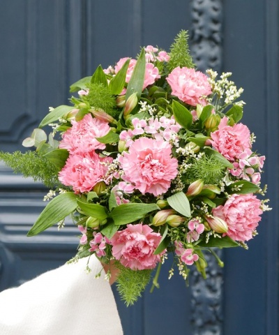 Ramo de flores cor-de-rosa e verdes em fundo de porta azul-escura