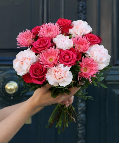 Ramo de flores mistas com rosas vermelhas, cravos cor-de-rosa e flores cor-de-rosa vibrantes