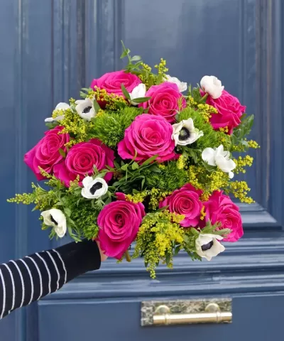 Bouquet colorido com rosas cor-de-rosa, flores brancas e folhagem verde