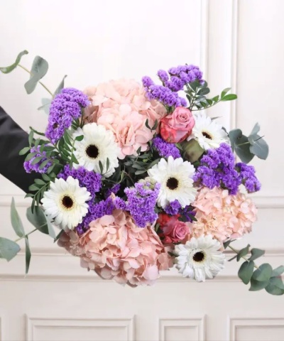 Buquê de flores com hortênsias rosa, flores brancas, flores roxas e folhas verdes