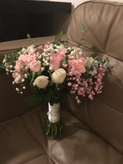 Bouquet de flores cor de rosa e branco num sofá castanho