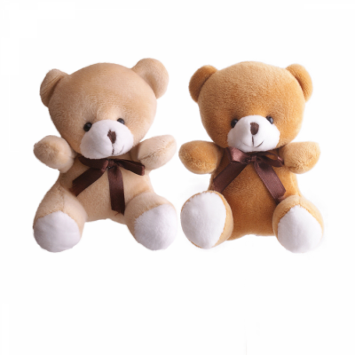 Dois ursinhos de pelúcia bege claro e castanho com laços castanhos ao pescoço