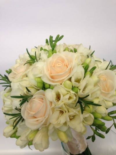 Ramo de flores creme e branco com folhas verdes num fundo branco