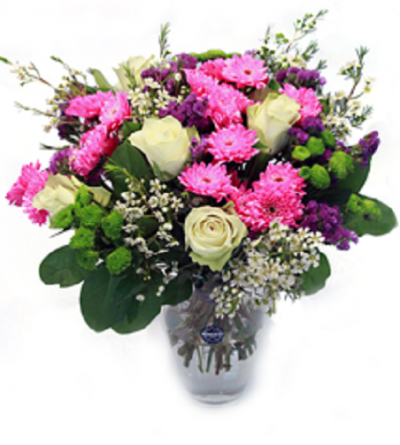 Arranjo floral colorido com rosa branca, cravos cor-de-rosa e folhas verdes em vaso de vidro