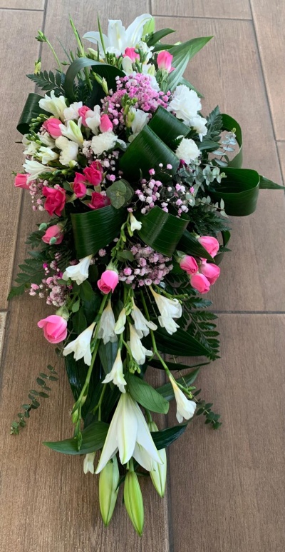 Arranjo floral com lírios brancos, rosas cor-de-rosa e folhagem verde