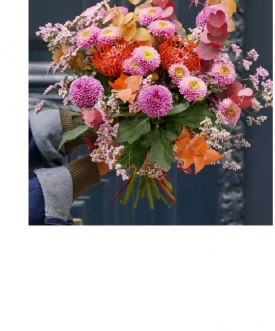 Buquê colorido de flores segurado por mão com luva