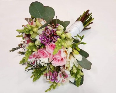 Ramo de flores colorido com rosas, flores brancas e verdes, e folhas verdes.