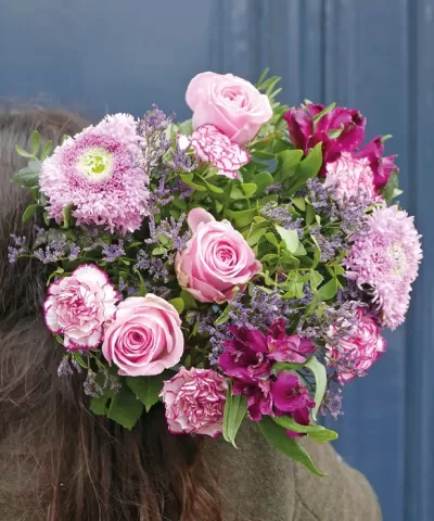 Bouquet de flores rosas e roxas com folhas verdes