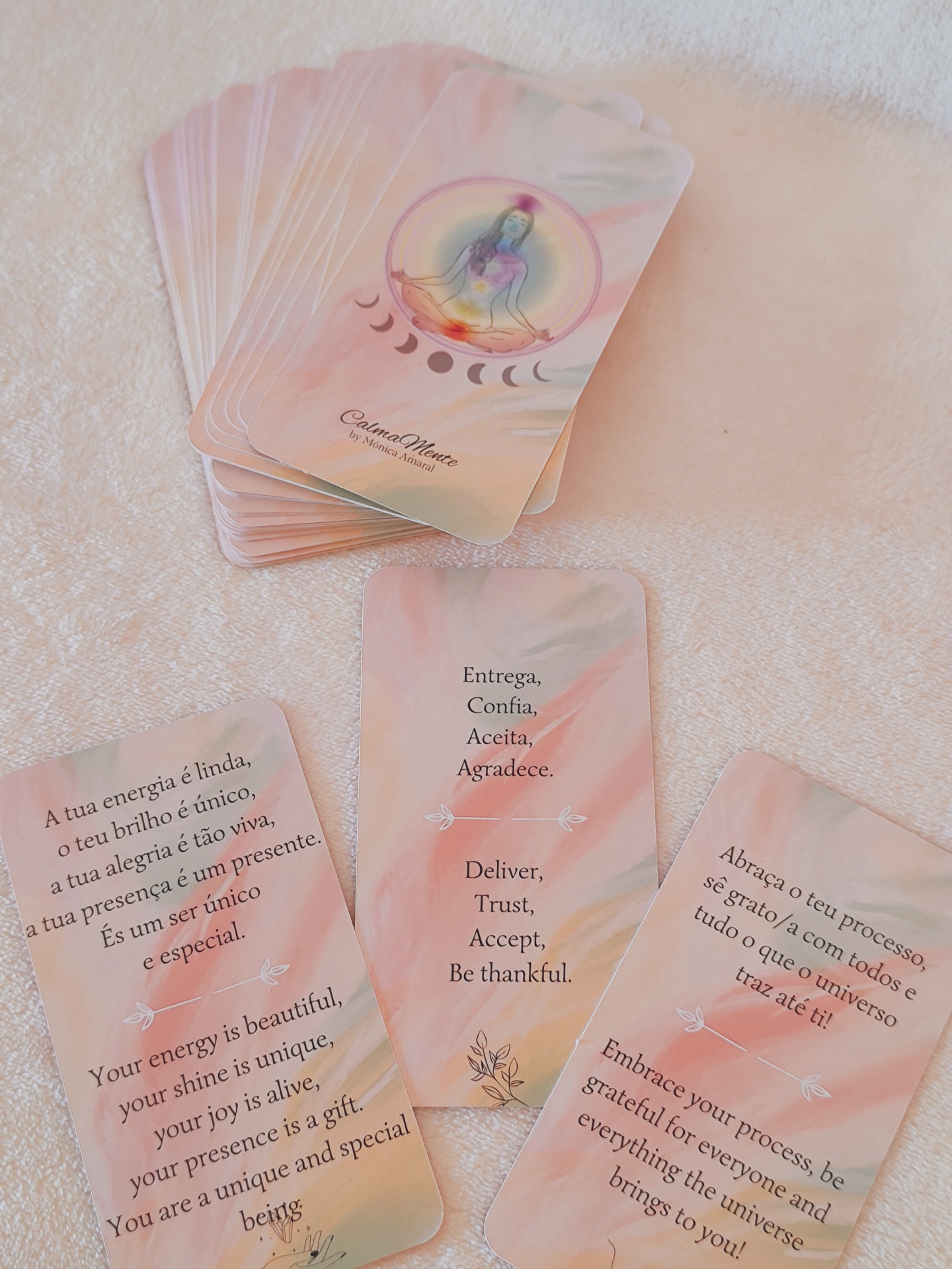 Oráculo CalmaMente Cartas coloridas com mensagens bilíngues e imagem de fases da lua sobre fundo branco texturizado
