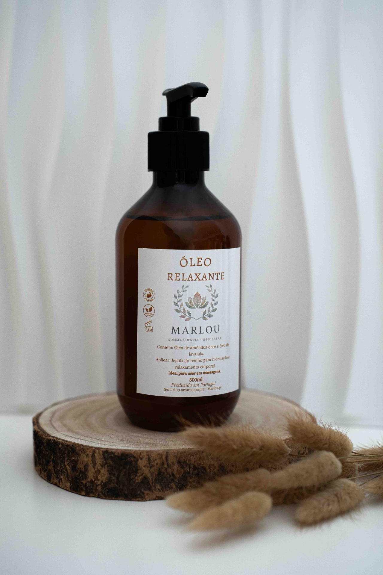 Óleo Relaxante Frasco castanho de óleo relaxante MARLOU com tampa doseadora preta em base de madeira