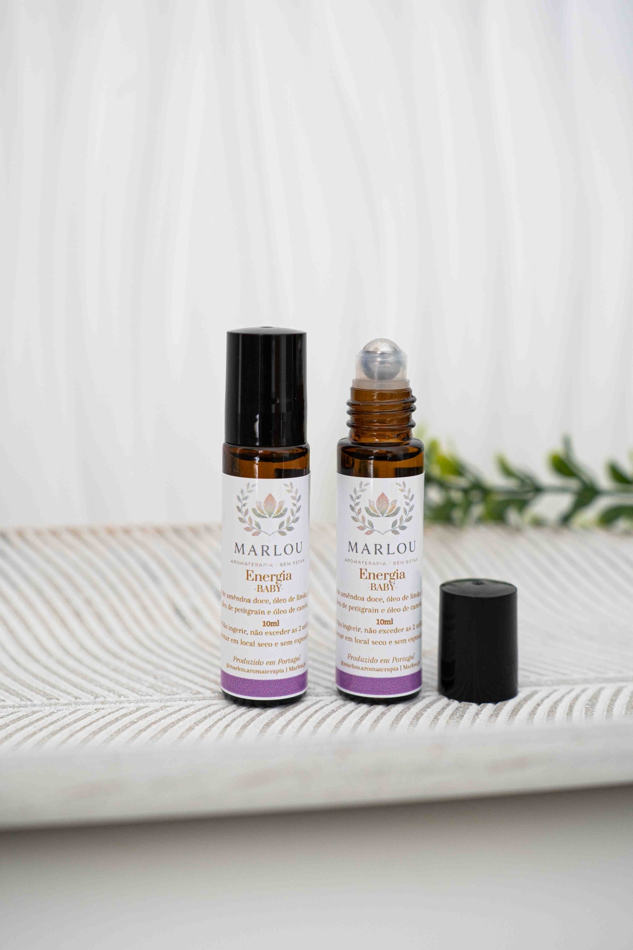 Roll on Energia Frascos de aromaterapia com rótulo MARLOU Energia Baby em frascos âmbar sobre superfície clara