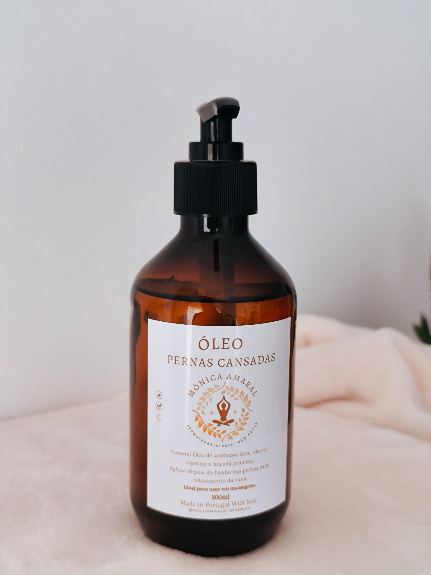 Óleo Pernas cansadas frasco âmbar com óleo para pernas cansadas, tampa de bomba preta, etiqueta branca com texto e símbolo, fundo neutro