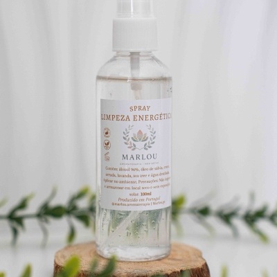 Frasco de spray transparente com etiqueta branca e texto castanho sobre base de madeira