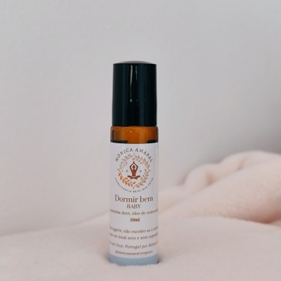 Frasco âmbar com etiqueta branca 'Dormir bem BABY' sobre tecido creme