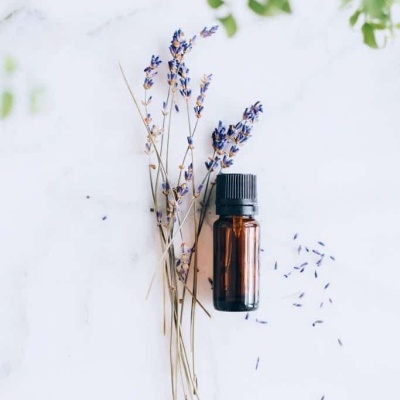 Frasco de vidro âmbar com lavanda seca ao lado