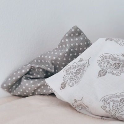 Duas almofadas com diferentes padrões e cores em superfície clara