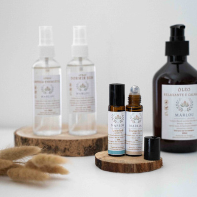 Produtos de aromaterapia MARLOU em frascos transparentes e castanhos com etiquetas brancas em base de madeira