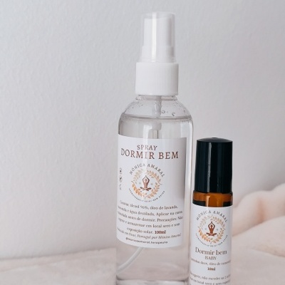 Spray e roll-on Dormir Bem com rótulos brancos em duas embalagens, spray transparente e roll-on âmbar, sobre superfície branca macia.