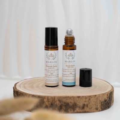 Dois frascos roll-on âmbar de aromaterapia MARLOU sobre base de madeira