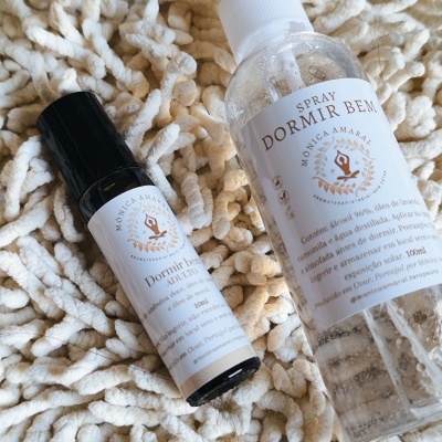 Frascos de spray 'Dormir Bem' com rótulos brancos sobre superfície creme texturizada