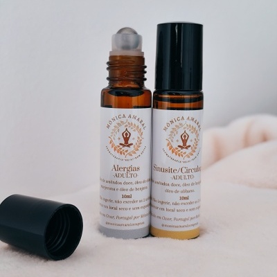 Dois frascos pequenos âmbar com rótulo branco e texto castanho-alaranjado para alergias e sinusite, com tampa preta separados sobre tecido claro.
