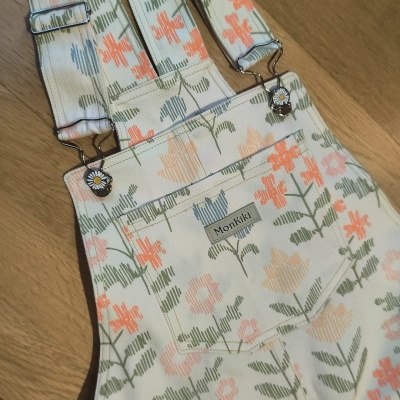 Jardineira com padrão floral e fechos com margaridas