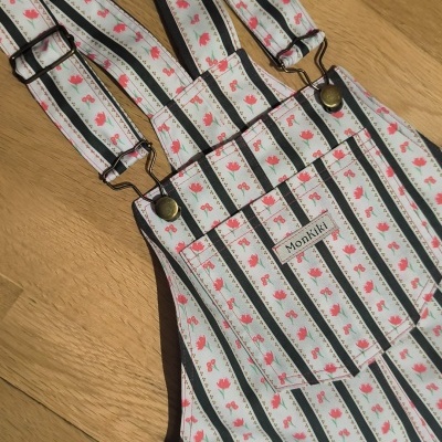 Jardineira com padrão de listras e flores em tecido sobre madeira