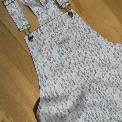 Jardineira floral lilás, roxo e verde com etiqueta Monkiki e alças reguláveis