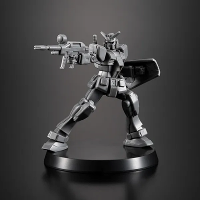 Figura robô metálico cinza com arma e escudo sobre base preta