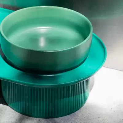 Utensílios de cozinha verdes escuros, taça lisa e prato texturizado