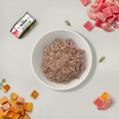 Taça branca com alimento húmido, lata Dibaq Sense Tuna with Rabbit, carne rosa e cubos alaranjados espalhados