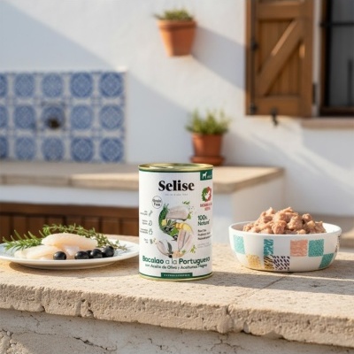 Lata de comida para cães Selise com bacalhau e dois pratos com alimento, fora de casa com parede branca e azulejos.