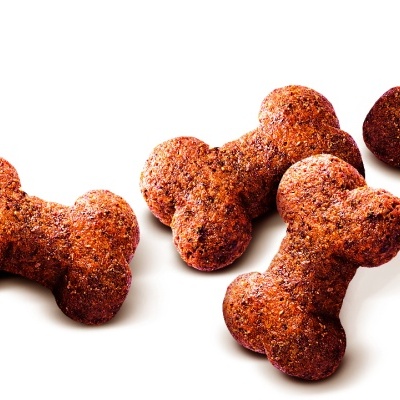 Quatro snacks para cães em forma de osso castanhos com textura granulada