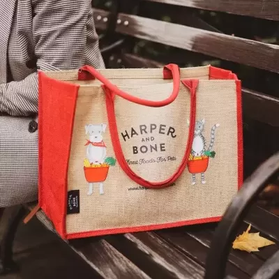 Saco de compras em juta com alças vermelhas e ilustrações de animais com legumes