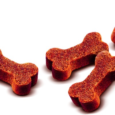 Biscoitos secos para cães em forma de ossos castanho avermelhados sobre fundo branco