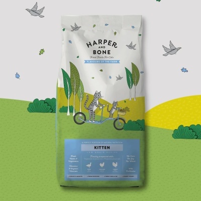Pacote de ração para gatinhos Harper and Bone com ilustração de gatos em bicicleta e paisagem