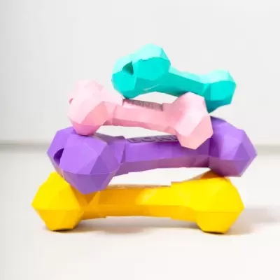 Halteres coloridos empilhados sobre superfície branca