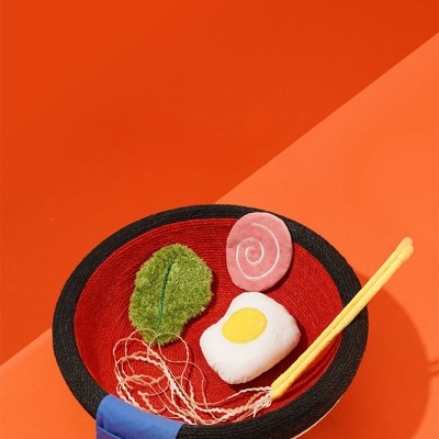 Conjunto de brinquedo em tecido representando uma tigela de ramen com alimentos e pauzinhos