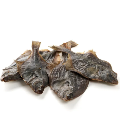 Quatro peixes secos com pele escura numa superfície branca