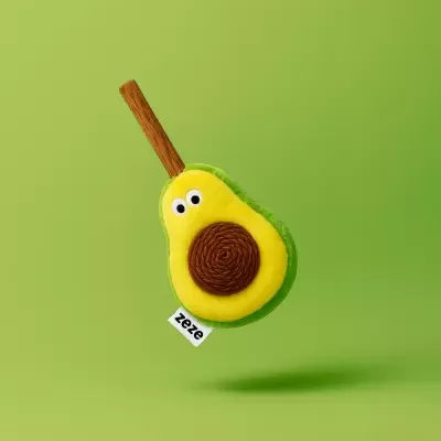 Brinquedo de pelúcia em forma de metade de abacate com olhos e caroço castanho