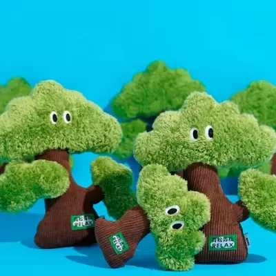 Peluches em forma de árvores verdes com olhos e etiqueta RELAX