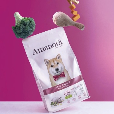 Pacote de ração Amanova Adult Obesity com ingredientes flutuantes em fundo rosa.