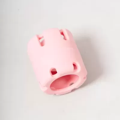 Peça cilíndrica de plástico cor-de-rosa com orifícios e slots