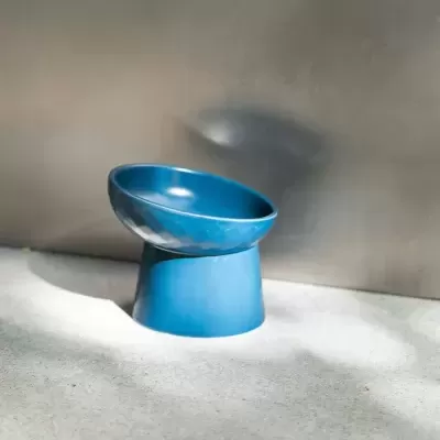 Taça azul de cerâmica com suporte inclinado e padrão facetado