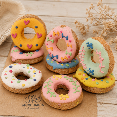 Donuts para cães coloridos decorados em fundo de madeira claro.